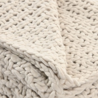 Manta branca de malha grossa dobrada com textura entrelaçada