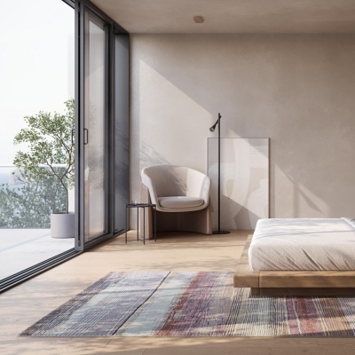 Quarto minimalista com cama, cadeira beige, tapete multicolorido e janela de vidro grande