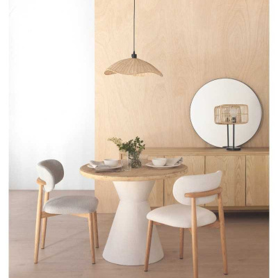 Mesa de jantar redonda com cadeiras estofadas e candeeiro suspenso em sala minimalista