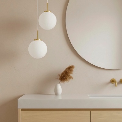 Lavabo moderno com bancada branca e armário de madeira clara com luzes pendentes e espelho redondo