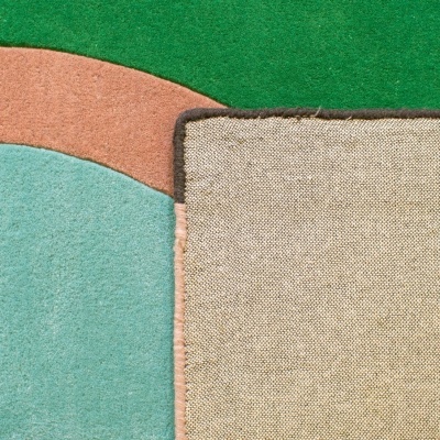 Canto de dois tapetes sobrepostos com texturas e cores diferentes.