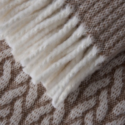 Detalhe de tecido bege e branco com franjas felpudas brancas