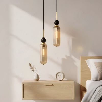 Quarto com mesa de cabeceira suspensa em madeira clara, jarra branca, relógio branco e lâmpadas pendentes com vidro âmbar