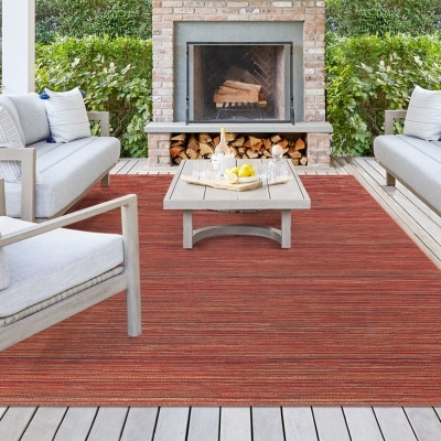 Zona de estar exterior com sofá, poltrona, mesa de centro e lareira