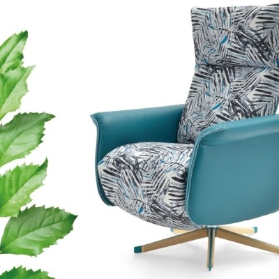 Cadeirão azul turquesa e estampado ao lado de uma planta verde