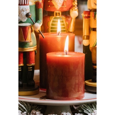 Velas vermelhas acesas rodeadas por soldados de brinquedo em madeira