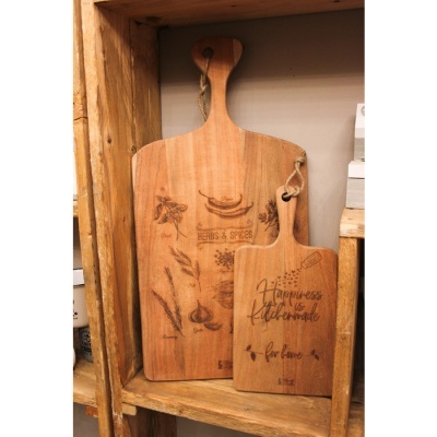 Duas tábuas de madeira para cozinha com textos e ilustrações, numa prateleira de madeira.