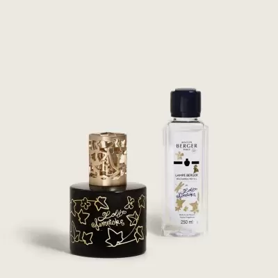 Difusor de aroma preto com padrão floral dourado e frasco de líquido transparente com rótulo branco
