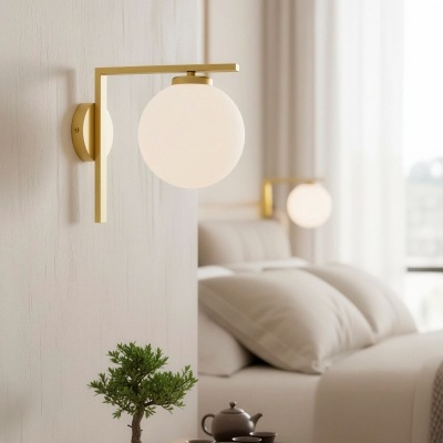 Candeeiro de parede dourado com cúpula branca esférica e mesa de cabeceira com bonsai e conjunto de chá