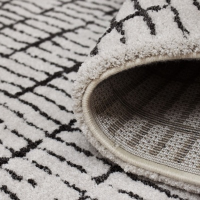 Tapete branco com padrão preto e bordas arredondadas.