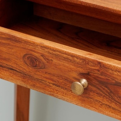 Cômoda em madeira castanha com gaveta aberta e puxador metálico