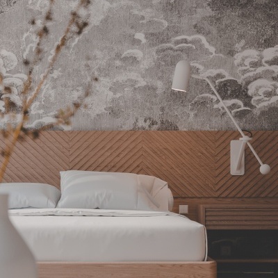 Cama de madeira clara com roupa branca e papel de parede com nuvens cinzentas