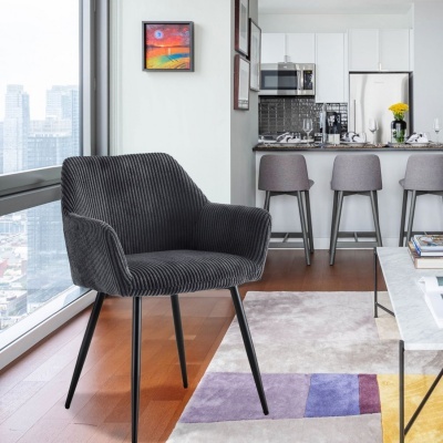 Cadeira cinzenta riscada com pernas pretas em sala moderna com cozinha ao fundo