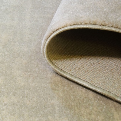 Tapete bege claro com bordas costuradas parcialmente enrolado