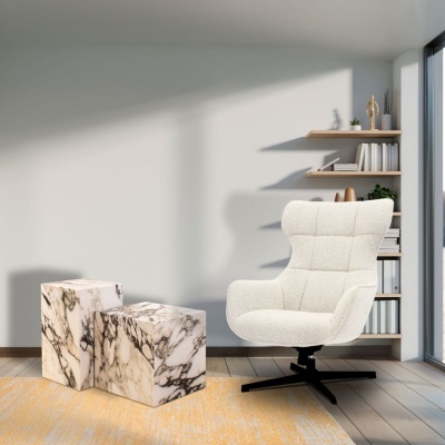 Cadeira branca almofadada ao lado de mesas com padrão de mármore em sala iluminada