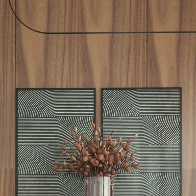 Vaso metálico com flores secas sobre superfície de madeira e duas telas geométricas