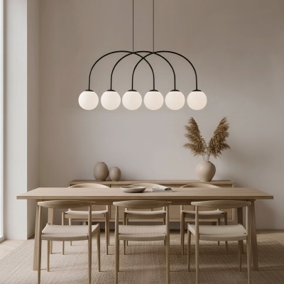 Sala de jantar com mesa e cadeiras em madeira clara e candeeiro pendente com globos brancos