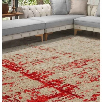 Tapete bege e vermelho com sofá bege e almofadas cinza e bege junto a janela e mesa lateral