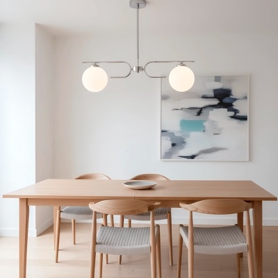 Mesa de madeira clara com quatro cadeiras e pendente de teto com duas esferas brancas