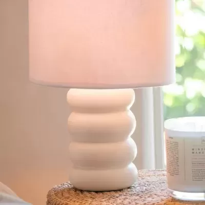 abajur branco com cúpula creme em mesa de fibras naturais
