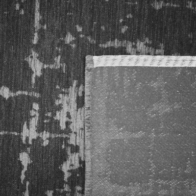 Tapete cinzento e preto com padrão abstrato e parte do verso com borda branca