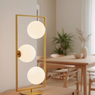 Abajur dourado com três globos brancos em móvel de madeira clara numa sala de jantar