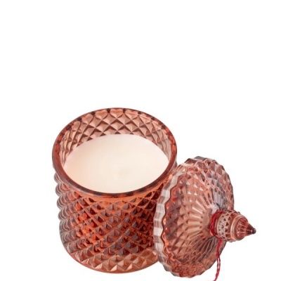 Vela branca numa jarra de vidro rosa com tampa e tassel vermelho.