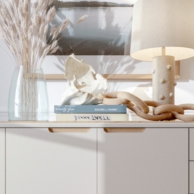 Aparador branco decorado com vasos de plantas secas, livros, escultura abstrata, corrente de madeira e candeeiro bege com textura, em ambiente iluminado