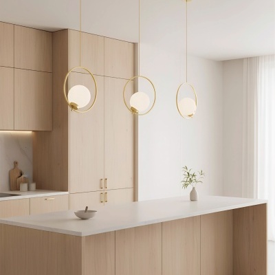 Cozinha com armários em madeira clara e candeeiros pendentes dourados com globos de vidro