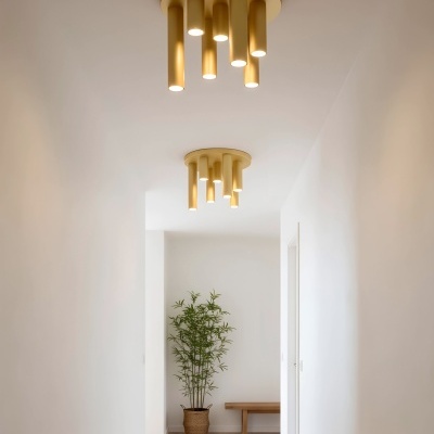 Luzes amarelas cilíndricas suspensas no teto num corredor branco com planta e banco de madeira