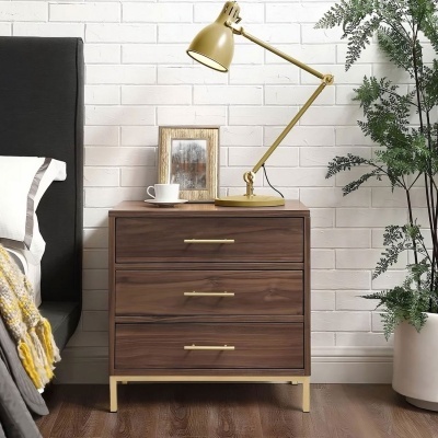 Mesa de cabeceira de madeira escura com lâmpada amarela e chávena branca