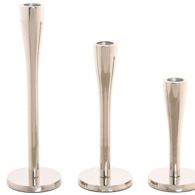 Três castiçais metálicos prateados de alturas variadas em fundo branco.