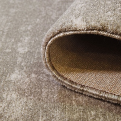 Tapete tecido bege com textura macia e bordas costuradas enrolado