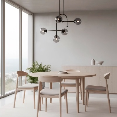 Mesa redonda de madeira clara com quatro cadeiras estofadas bege, luminária moderna e aparador num ambiente minimalista