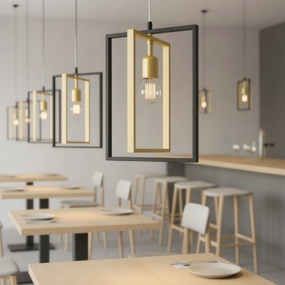 Luzes pendentes quadradas pretas e douradas numa sala de jantar moderna com mesas e cadeiras de madeira clara