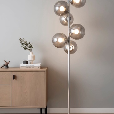 Candeeiro de pé com globos de vidro fumado e móvel de madeira claro