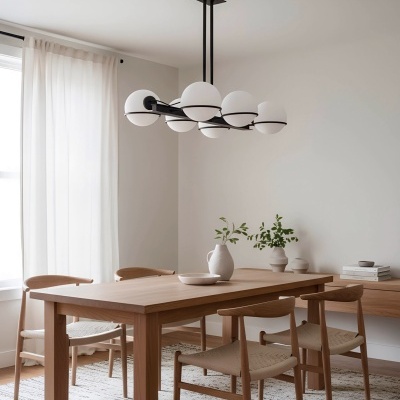 Sala de jantar com mesa e cadeiras de madeira clara, luminária com globos brancos e decor minimalista