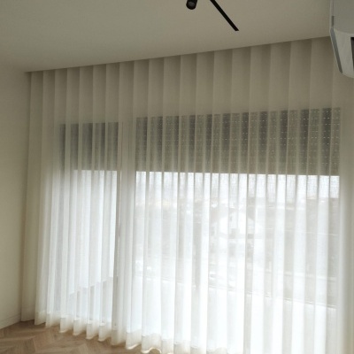 Cortina branca translúcida em janela ampla com chão em madeira clara