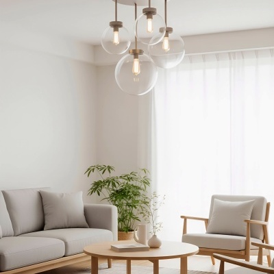 Sala de estar com móvel de madeira clara, sofá cinza, poltronas, mesa redonda e candeeiro moderno no tecto.