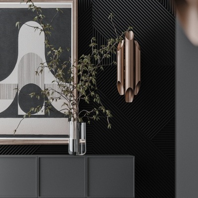 Aparador cinzento com vaso e quadro, parede preta texturizada, luminária metálica dourada