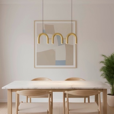 Mesa de jantar com tampo branco e cadeiras de madeira clara, luminárias douradas pendentes e quadro abstrato na parede.