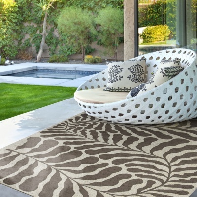 Cadeira exterior branca redonda com almofadas e tapete detalhes naturais