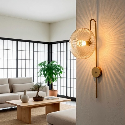 Luminária de parede dourada com cúpula de vidro texturizado acesa em sala de estar moderna
