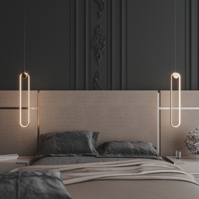 Quarto com cama de casal, cabeceira bege, roupa de cama cinzenta, paredes cinzentas decorativas, luzes pendentes douradas e mesas de cabeceira.