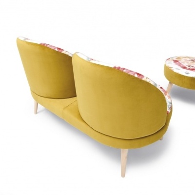 Sofá amarelo com padrão floral e otomana