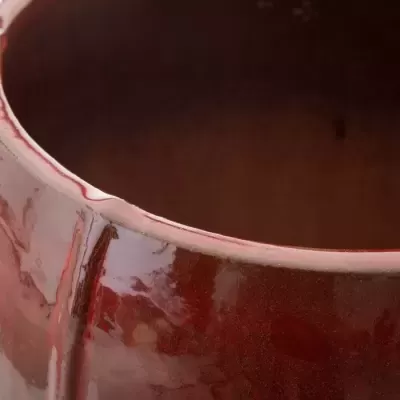 Vaso de cerâmica vermelho escuro com acabamento vidrado brilhante