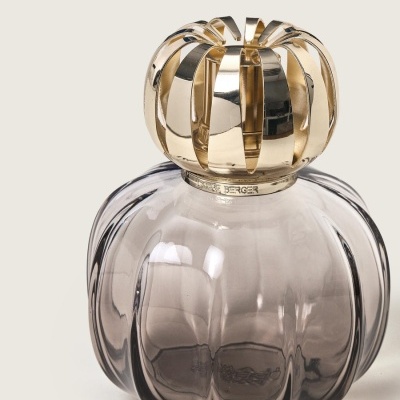 Frasco de vidro cinza com tampa dourada em forma de coroa