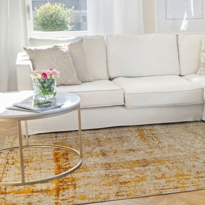 Tapete castanho e laranja num quarto com sofá branco e mesa redonda com flores