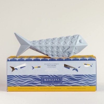 Peixe decorativo cinzento sobre caixa azul com ilustrações de peixes e texto MANULENA