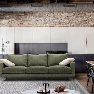 Sofá verde numa sala de estar moderna com parede de tijolos